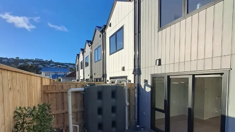 Private rear courtyard at 21 Derwent Street with a large dark-framed sliding door and upper-level aluminium windows.