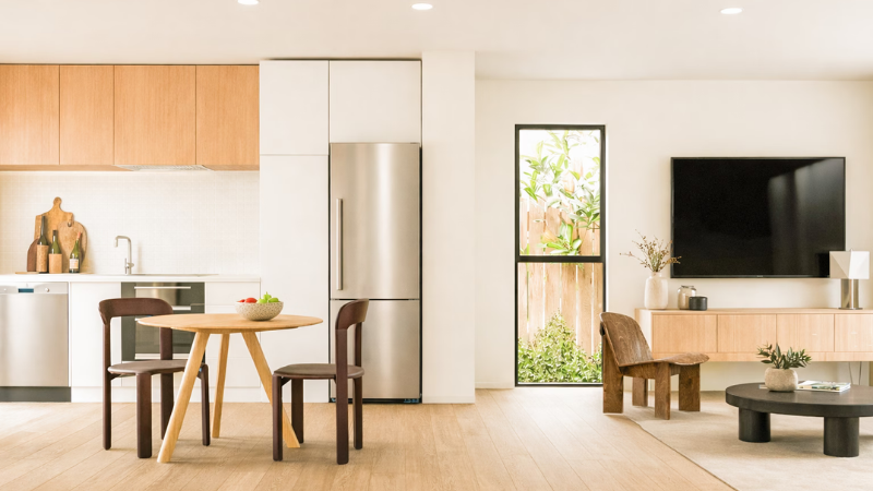 Open-plan kitchen and living area featuring modern finishes, large aluminium windows, and a light-filled interior.