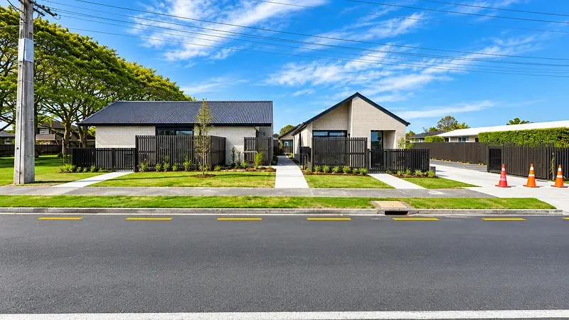 Street frontage of 299 Levers Road, Matua, Tauranga, with two brick homes either side of the shared pathway
