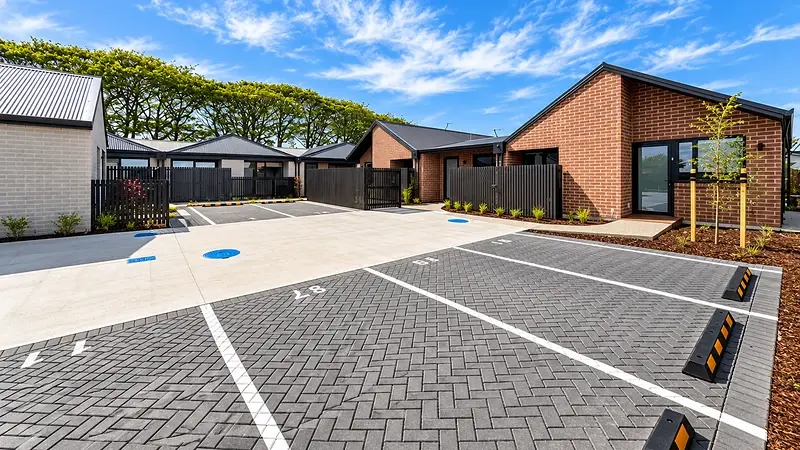 Shared parking area at 299 Levers Road, Matua, Tauranga, with red and white brick homes and aluminium windows and doors