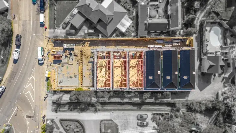 Top-down drone view of the 41 Whitemans Road site in Upper Hutt, showing townhouses at the framing and roofing stages.