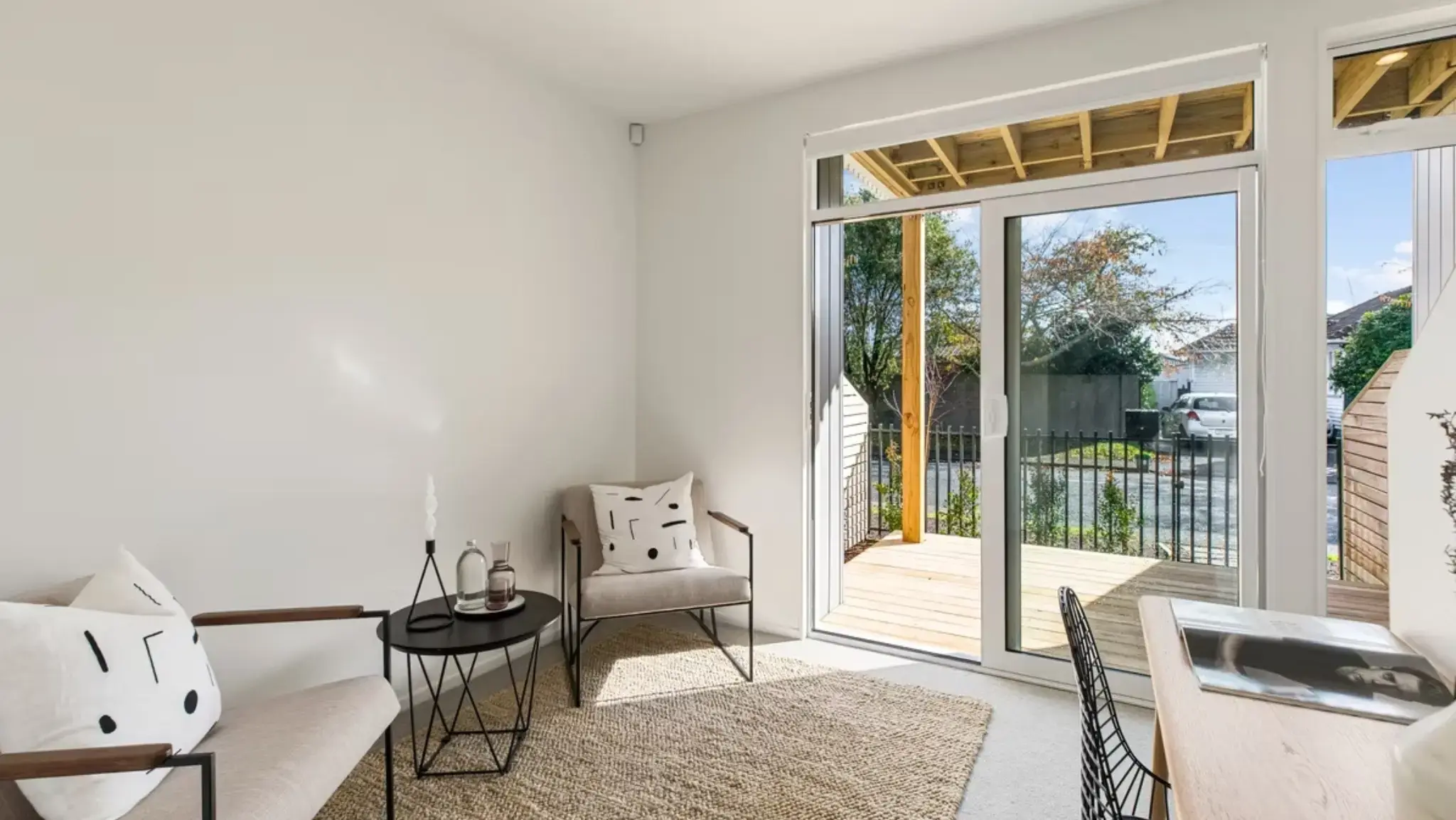 Ground-floor study or living space opening onto a timber deck through an aluminium sliding door.