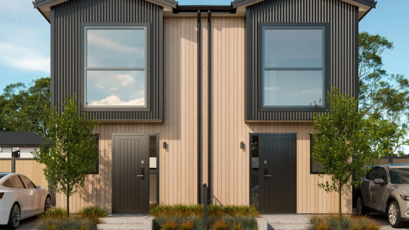 Modern multi-residential townhouse development with black vertical cladding, large windows, landscaped frontage, and parked SUV.