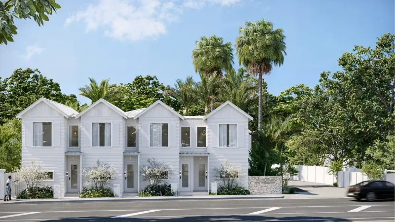 Front elevation of white architecturally designed townhouses with large aluminium windows, landscaped gardens, and tropical surroundings.