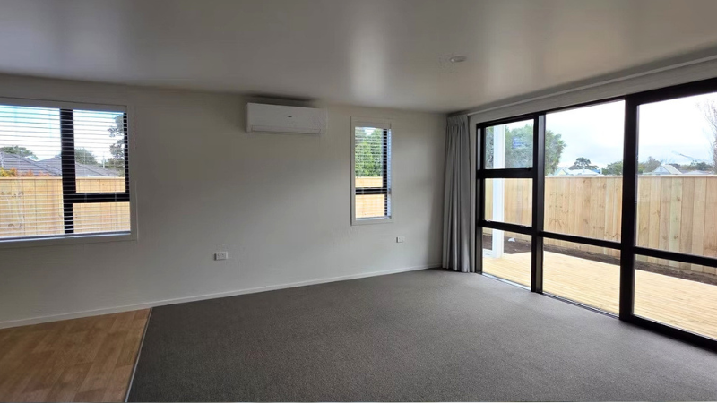Open-plan living area with aluminium sliding doors and large windows in multi-residential development New Zealand