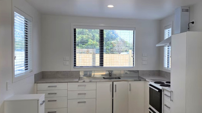 Modern kitchen with aluminium window above sink in residential development New Zealand