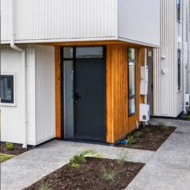 Durable aluminium entry door with sidelights in a modern townhouse, designed for security, acoustic performance, and a beautifully simple street presence