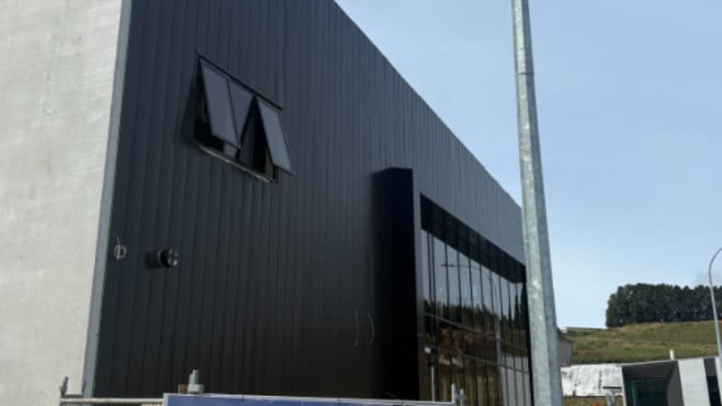 Commercial building with black aluminium cladding and awning windows integrated into a modern façade in New Zealand.