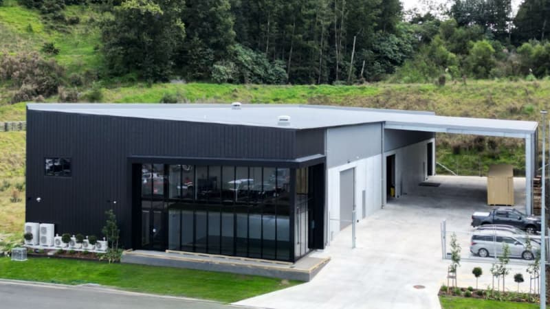 Aerial view of modern commercial building with aluminium façade, large glazing system, and surrounding landscape.