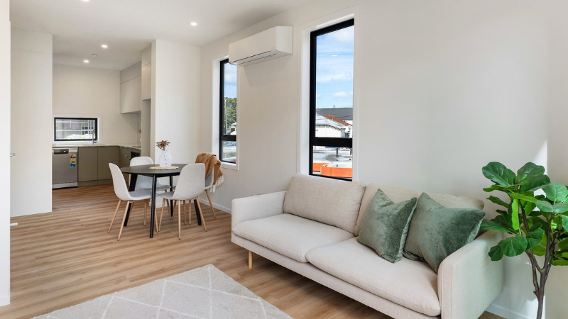 Open-plan living area with large aluminium windows bringing natural light into the townhouse interior.