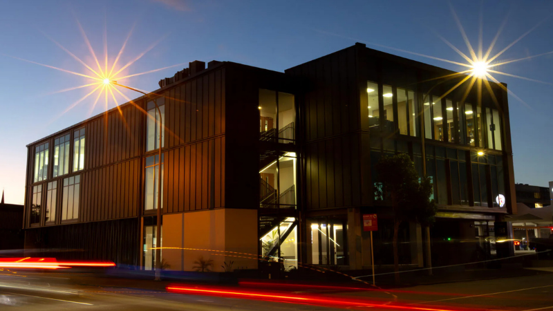 Leach Street Development at dusk showing illuminated offices and extensive commercial glazing.