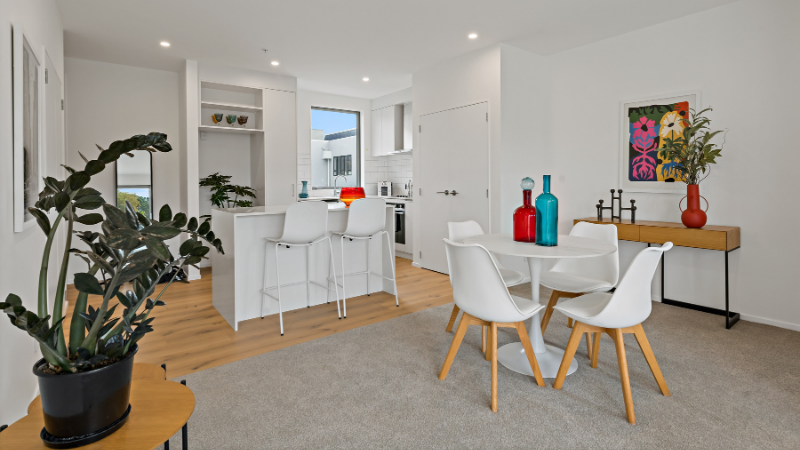 Open-plan kitchen and dining area inside Norana Townhouses featuring large aluminium windows and contemporary finishes.