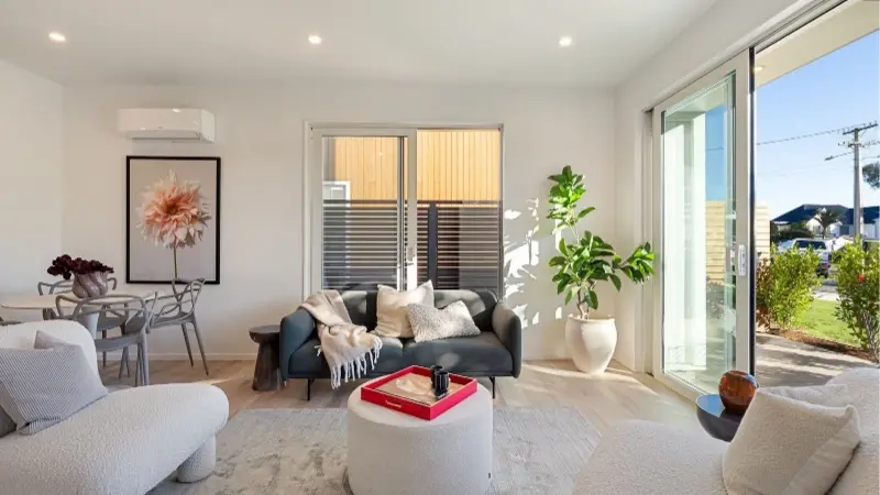Open plan living area with aluminium sliding doors and large windows providing natural light and ventilation.